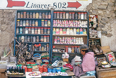 Indigenous woman selling traditional medicinal and other pbjects at a street stall in La Paz, Bolivia